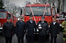 Goscie bioracy udzial w przekazaniu na tle samochodu