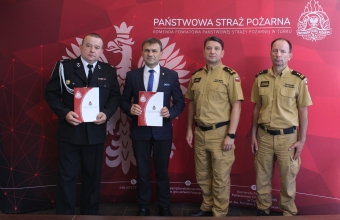 4 mezczyzn stoi na tle czerwonej sciany