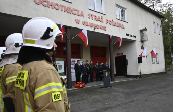 na pierwszym planie strazak strazak na drugim budynek strazy