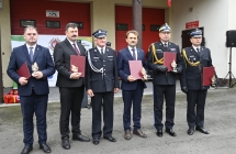 szesciu mezczyzn trzymajacych czerwone teczki i statuetke