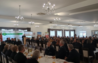 sala z siedzacymi przy stolach strazakami