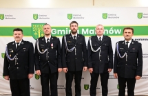 strazacy w mundurach na tle scianki reklamowej