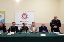 grupa osob przy zielonym stoliku jedna osoba stoi